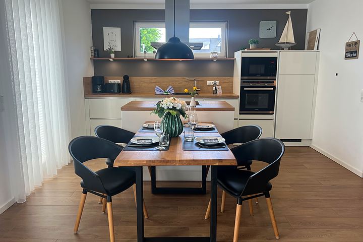 Laid dining table in front of the kitchen