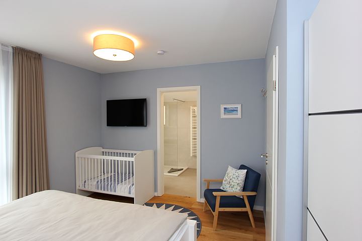 Bedroom with double bed, cot and access to the bathroom