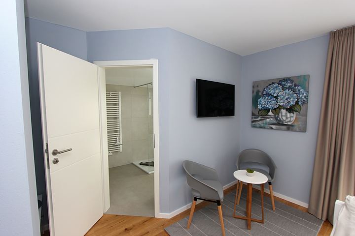 Seating area in the bedroom with view into the bathroom