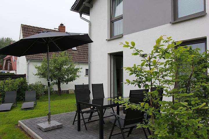 Terrace with parasol and sun loungers by the house