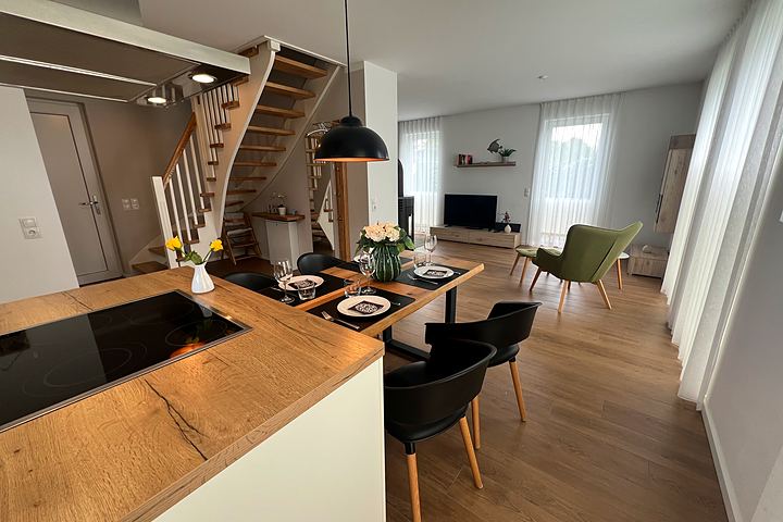 Open-plan living area with kitchen, dining area and stairs